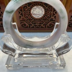 Clear jade ring on decorative stand.