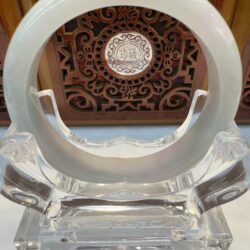 Translucent jade bangle on clear acrylic stand