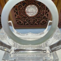 Polished white jade circle resting on stand