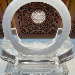 Circular milky jade hoop displayed on acrylic