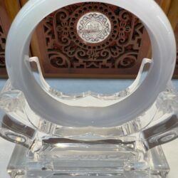 Glossy white jade bangle centered on acrylic