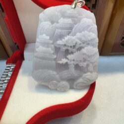 White jade pendant with intricate carvings displayed.