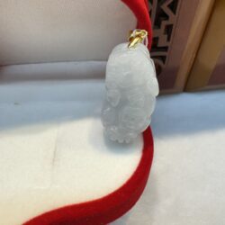 White jade pendant with red velvet lining.