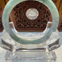 Translucent circular jade bracelet with wood backdrop