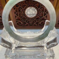 Circular jade bracelet on crystal stand
