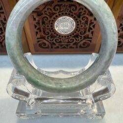 Translucent green jade hoop on clear pedestal