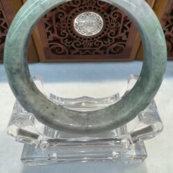 Polished green jade bangle against wood