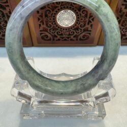 Round light green jade bracelet displayed vertically