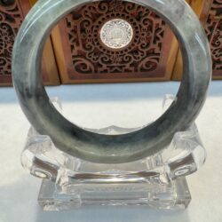 Gray green jade bangle on pedestal