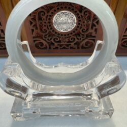 Circular crystal sculpture on decorative wooden background.