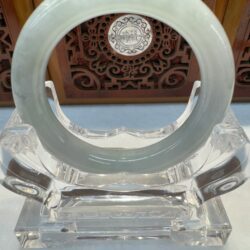 Jade bangle on decorative clear stand.