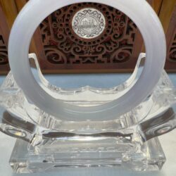 Translucent circular jade bangle with carved backdrop