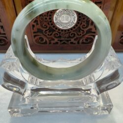 Pale green jade bangle on acrylic display