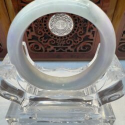 Smooth translucent jade bangle with crystal stand
