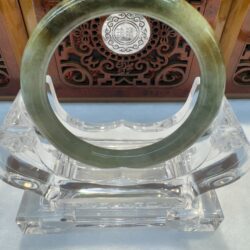 Olive-toned jade bracelet with carved backdrop