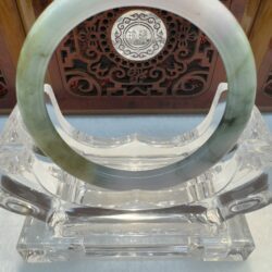 Light green jade bangle on acrylic stand