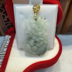 Jade pendant in ornate red display case.