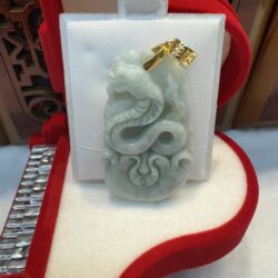 Jade pendant with dragon design in box.