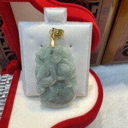 Green jade pendant in red display box.