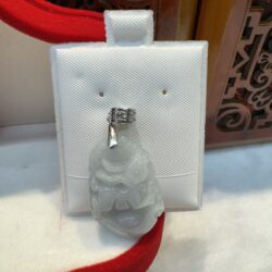 Jade pendant on white display with pattern.
