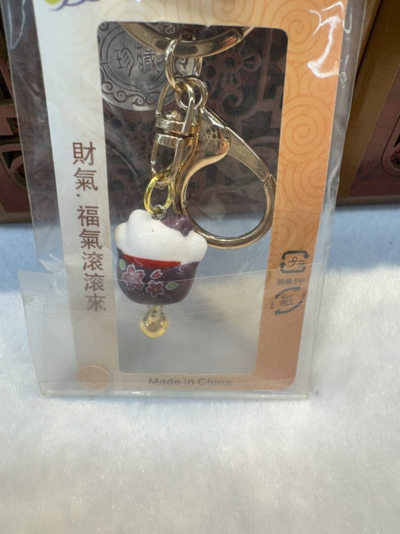 Keychain with decorative cup and bell.