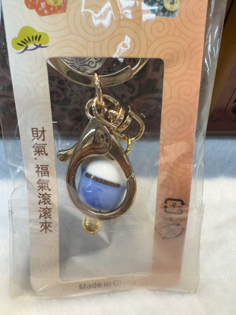 Decorative keychain with blue and white bead.