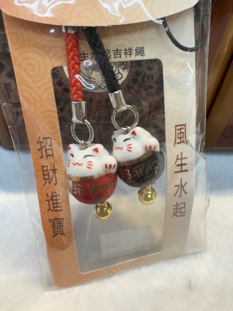 Lucky cat charms with gold bells.