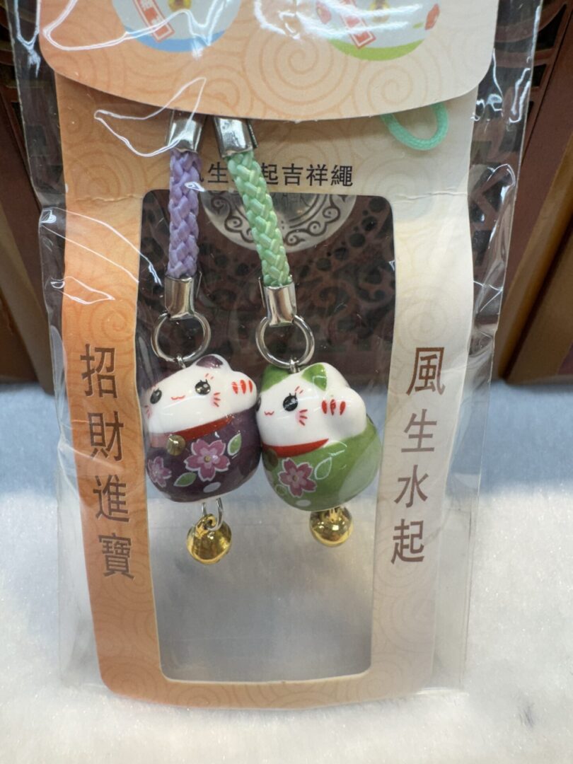 Lucky cat charms with floral design packaging.