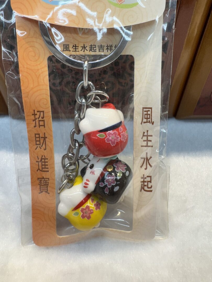 Lucky cat keychains in packaging with kanji.