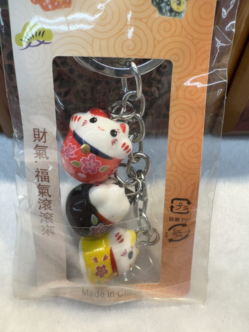 Lucky cat keychains in packaging.