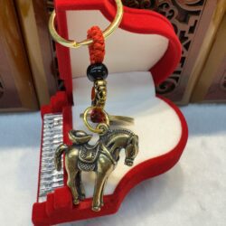 Bronze horse keychain in red box.