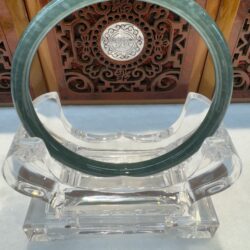 Deep green jade circular bracelet on stand