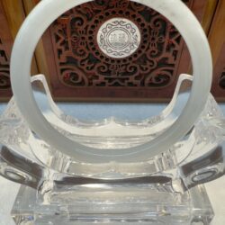 Jade bangle framed by decorative wooden panel