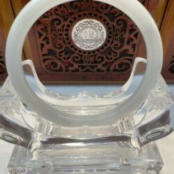 Pale white jade circle on crystal stand