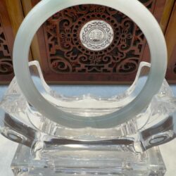 Crystal ring on ornate wooden background display.