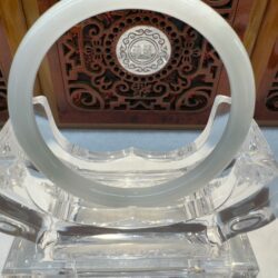 Jade circle on an ornate wooden stand.