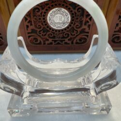 Crystal and jade ring on ornate stand.