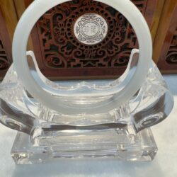 Elegant jade bangle centered against ornate carving