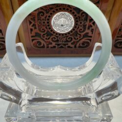 Light green jade bangle with wood backdrop