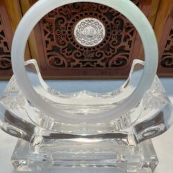 Icy white jade bangle on clear stand