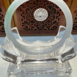 Transparent sculpture with intricate wooden background.