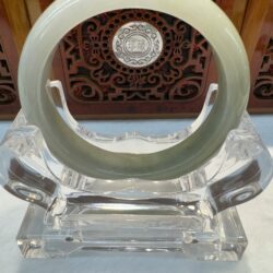 Jade bangle on decorative transparent stand.