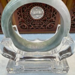 Circular jade bracelet centered on clear holder