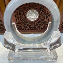 Jade ring on a clear stand.