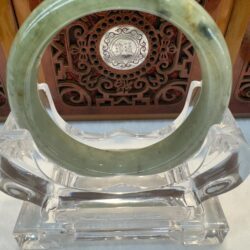 Circular green jade bracelet with wood backdrop