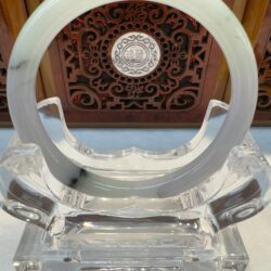 Crystal and jade sculpture with intricate background.