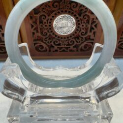 Glass ring on ornate wooden stand.