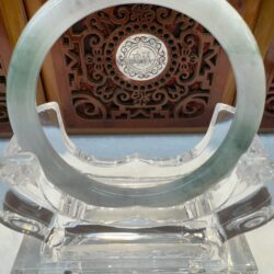Jade ring on an ornate wooden stand.