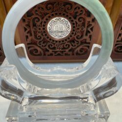 Pale green jade bangle on crystal stand