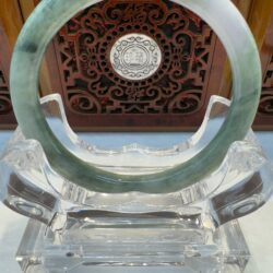 Light green jade bangle centered on crystal holder